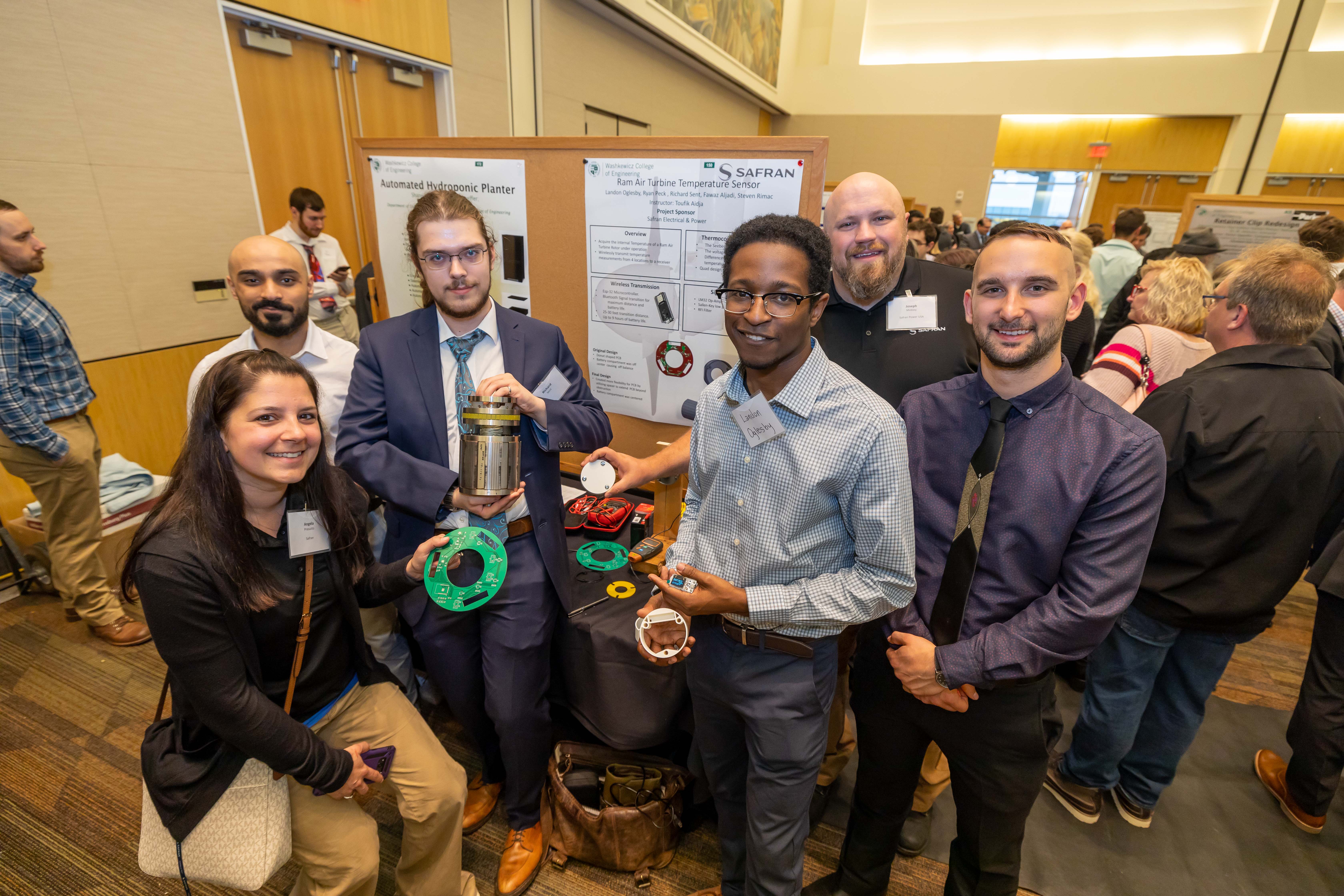 senior design students in front of project poster