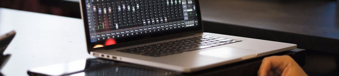 A student with a laptop using an audio editing software app.