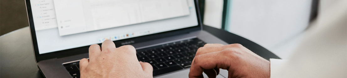 An employee working on graphs and data on a laptop.