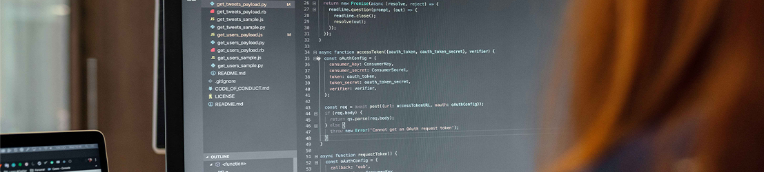 A female student working on code on a computer monitor.