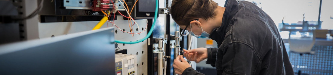 A student working on lab equipment in a classroom.