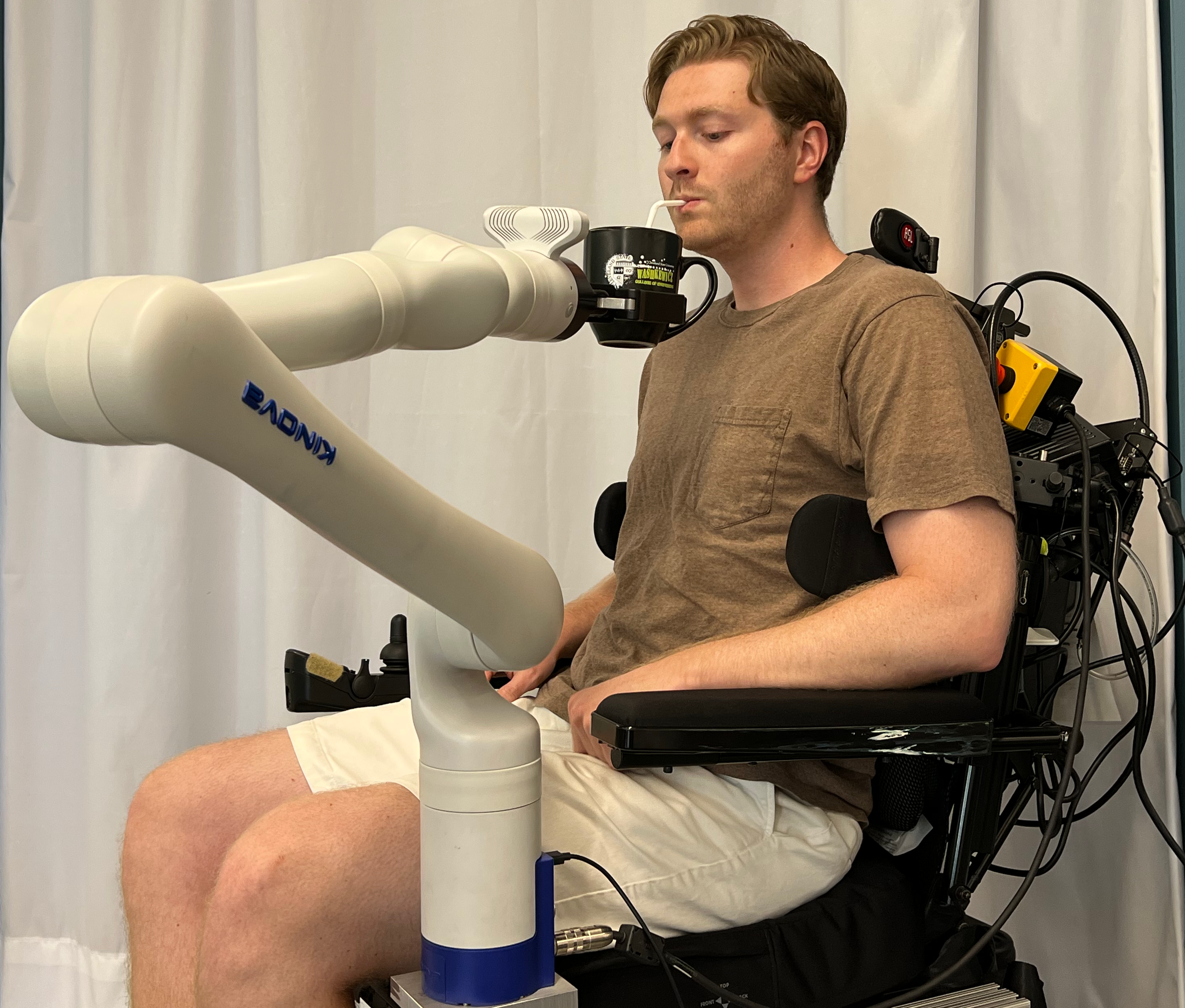 a robot serves a drink to a person in a wheelchair