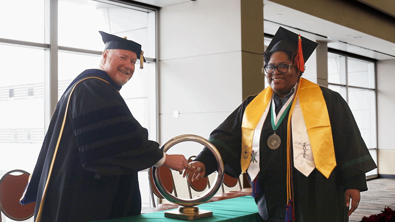 Dean Richard shaking student's hand