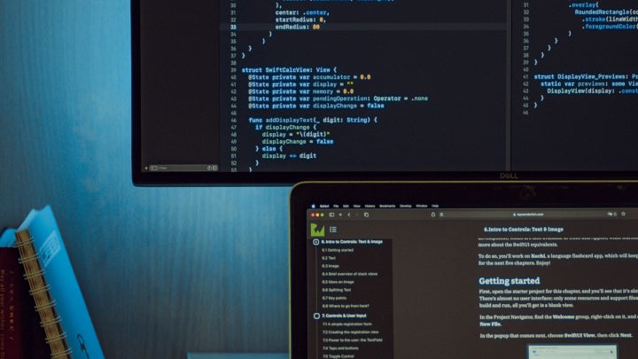 A laptop and a large computer monitor displaying code.