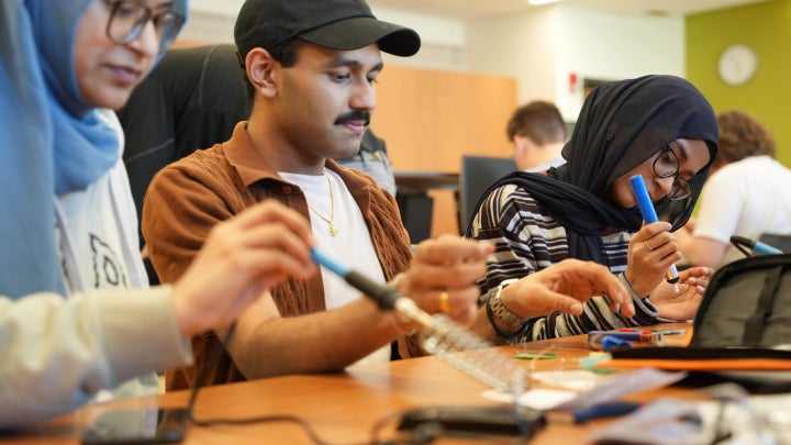 IEEE and HKN officer Akshat assisting students with soldering during the workshop