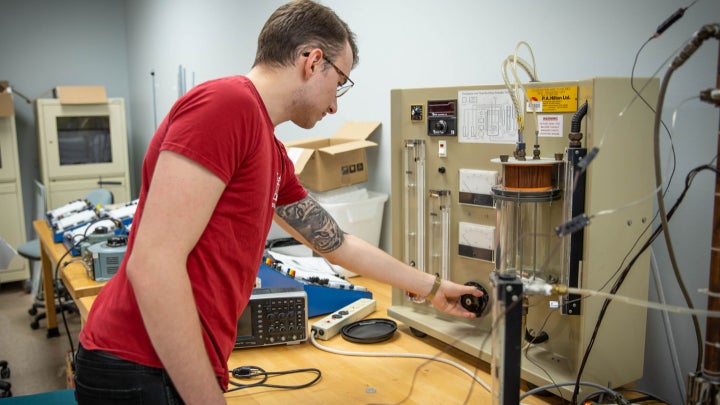 A student working on research equipment in a classroom.