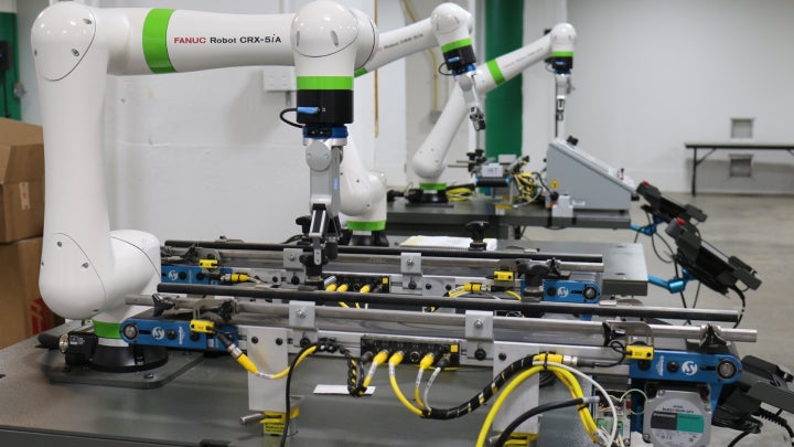 Three robotic arms in a research lab.