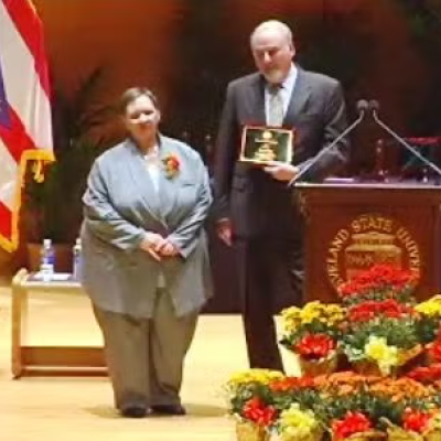 Becky Laird on stage receiving the Distinguished Staff Service Award.
