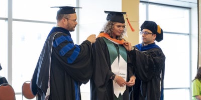 master's student being hooded by advisor