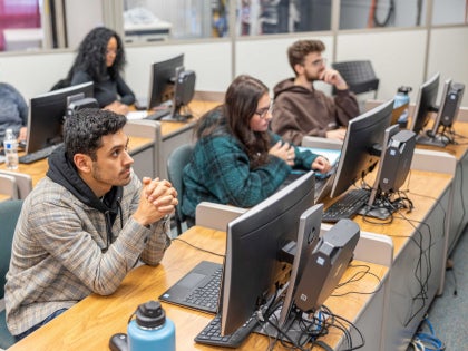 A group of students listening to a lecture in a classroom.
