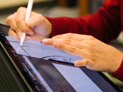 A person drawing with a digital pen on a tablet.