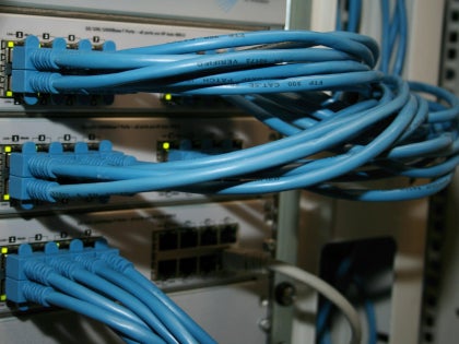 Multiple blue cables connecting into a network router.