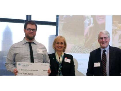 A student and two professors posing for a photo for winning competition.