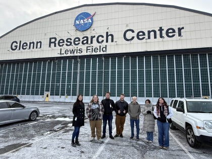 A group of students posing for a picture outside the NASA Glenn Research Center.