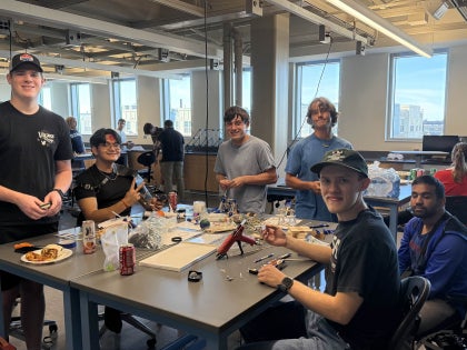 A group of students working on a project inside a classroom.