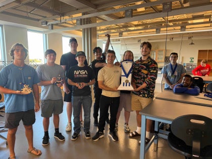 A group of students posing for a picture inside a classroom.