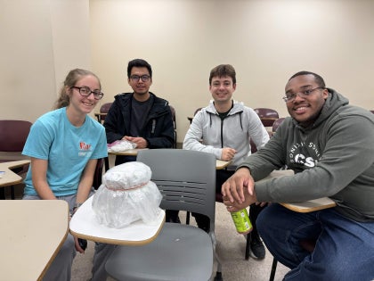 A group of students posing for a picture inside a classroom.