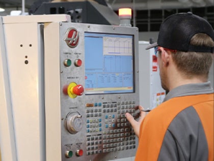 A student typing buttons on a machine in a lab.